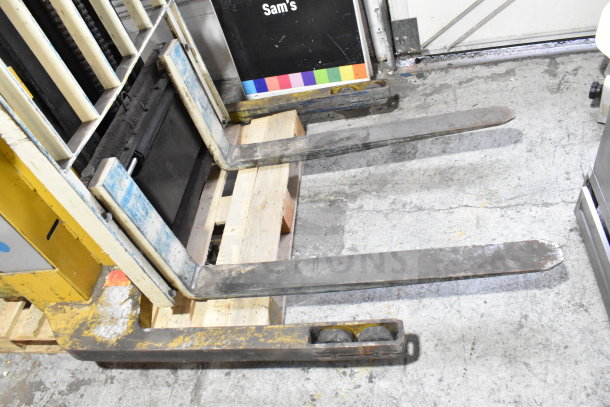 Yale E Industrial Walkie Stacker, walk behind model in used condition, visible wear on forks, includes pallet jack wheels.