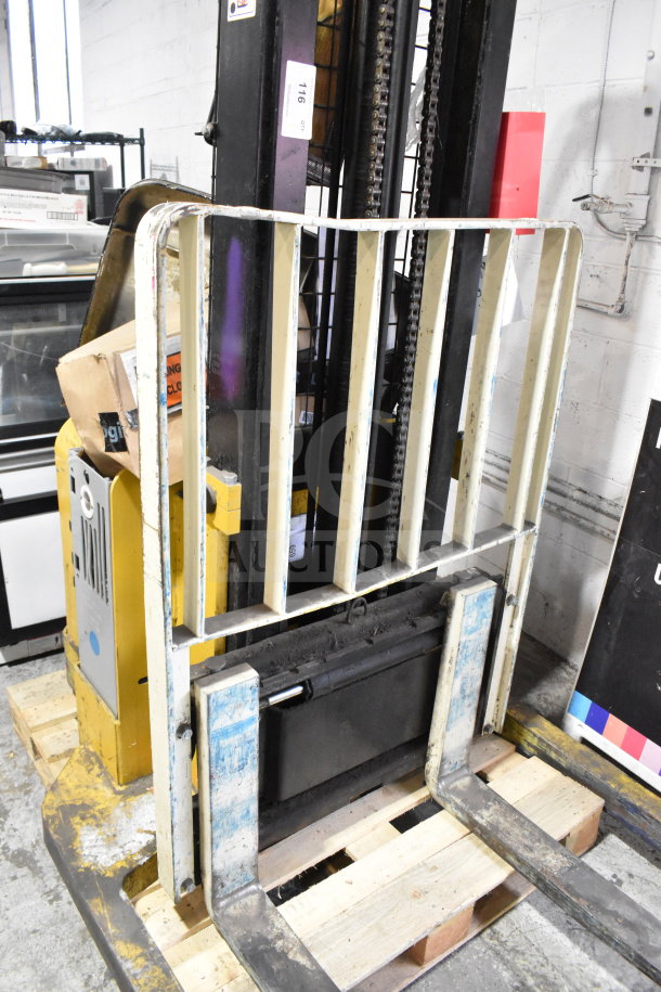 Yale E Industrial Walkie Stacker, walk-behind model. Yellow with load platform, visible wear, and operational components.
