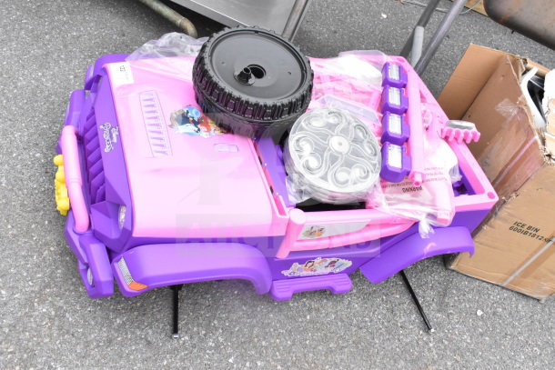 Pink and purple Princess ride-on children's vehicle with decorative decals and unassembled wheels, in new condition.