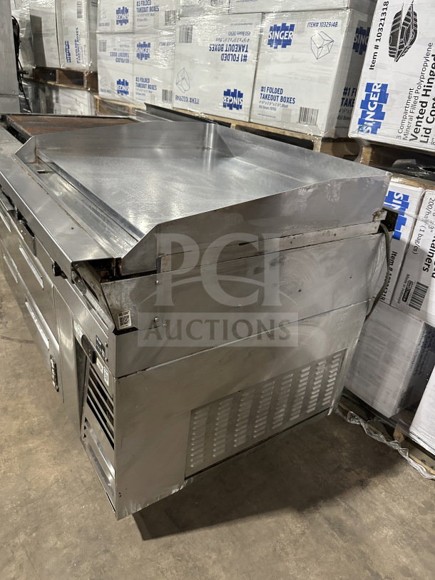 Stainless steel 4-drawer refrigerated chef base with gas charbroiler & griddle, on casters. Good condition, commercial-grade.