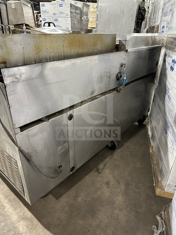 Commercial stainless steel 4-drawer refrigerated chef base with gas radiant charbroiler and griddle on casters. Used condition.