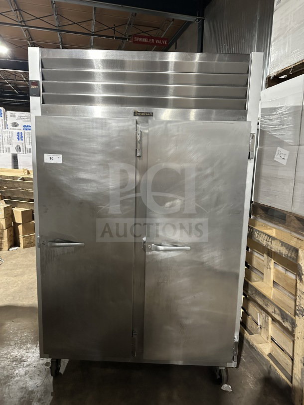Traulsen G22012 commercial stainless steel 2-door reach-in freezer, poly coated wired rack, good condition, on casters.