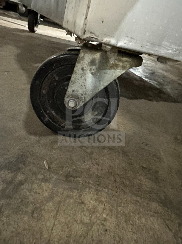 Wheel of Traulsen G22012 commercial freezer on casters, showing condition and mobility features.