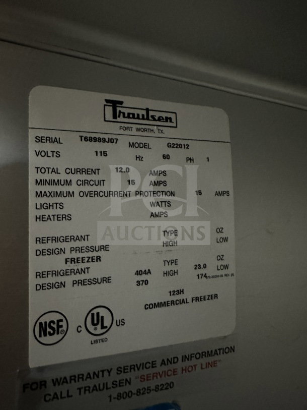 Traulsen G22012 commercial stainless steel 2-door reach-in freezer with poly coated racks, on casters. Model and serial labels visible.