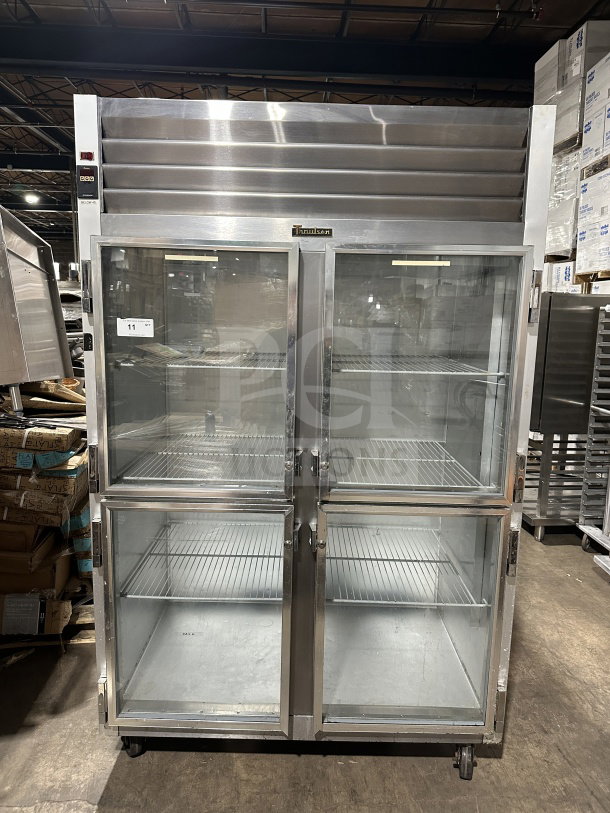 Traulsen G21000 commercial refrigerator, stainless steel, 2-section, 4-half glass doors, poly-coated wire racks, on casters.