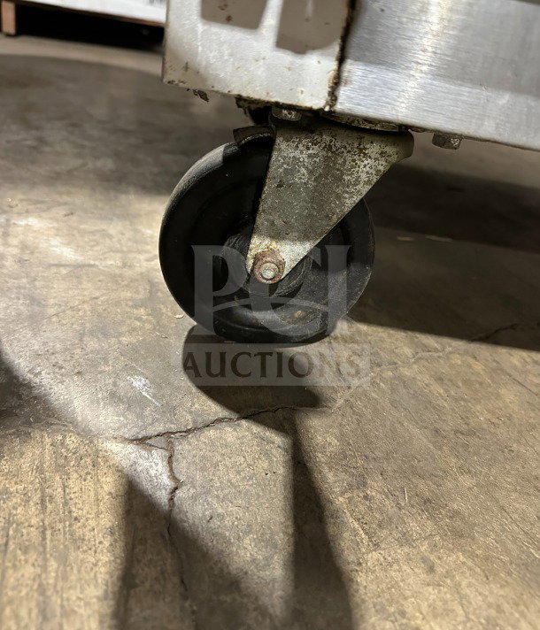 Traulsen G21000 commercial fridge caster showing wear on stainless steel base, ideal for maneuverability.