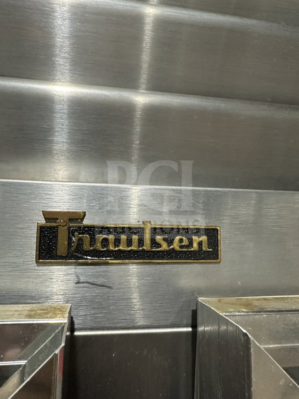Traulsen G21000 commercial stainless steel refrigerator with two sections, four half-glass doors, poly-coated rack, on casters.