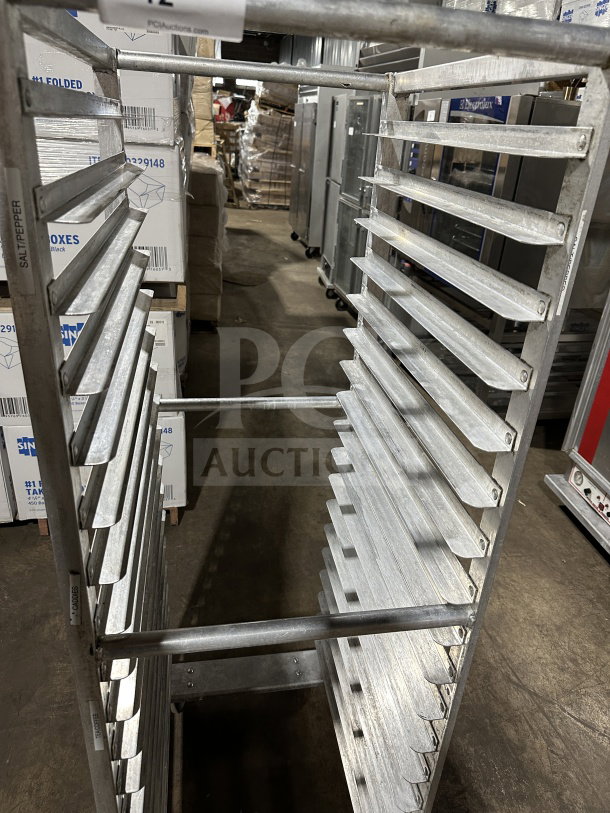 Commercial stainless steel welded pan rack with multiple slots, on casters, in good condition.