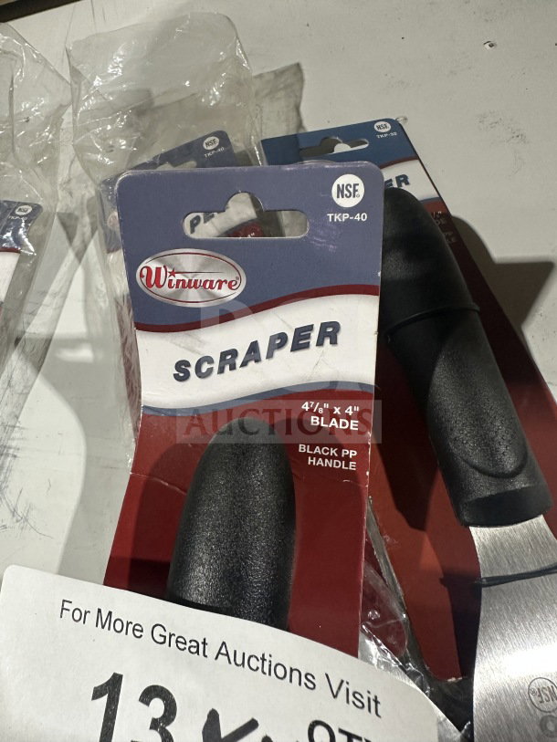 Brand new Winco TKP40 handheld scraper, stainless steel, 4¾" x 4" blade, black slip-resistant handle, in packaging.