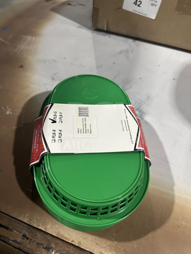 Brand new Winco Winware green oval fast food serving basket, commercial grade, with label indicating 1 dozen per case.