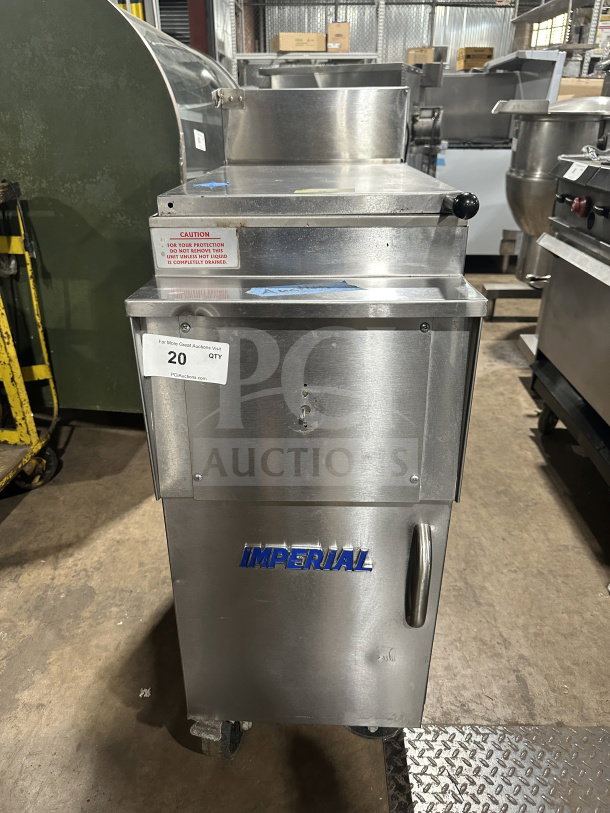 Imperial commercial stainless steel natural gas deep fat fryer with back splash, on casters. Brand logo and caution sticker visible.