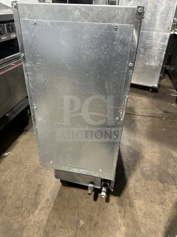 Imperial commercial stainless steel deep fat fryer, natural gas powered, with back splash, on casters, shown from the back.