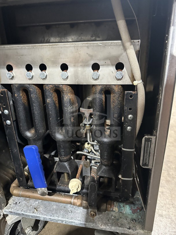 Imperial commercial stainless steel natural gas deep fat fryer. Features back splash, casters, and visible burners.