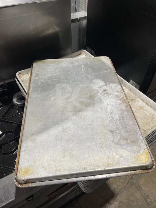 Commercial aluminum full-size baking sheet pan, used condition, visible wear, ideal for large-scale baking needs.