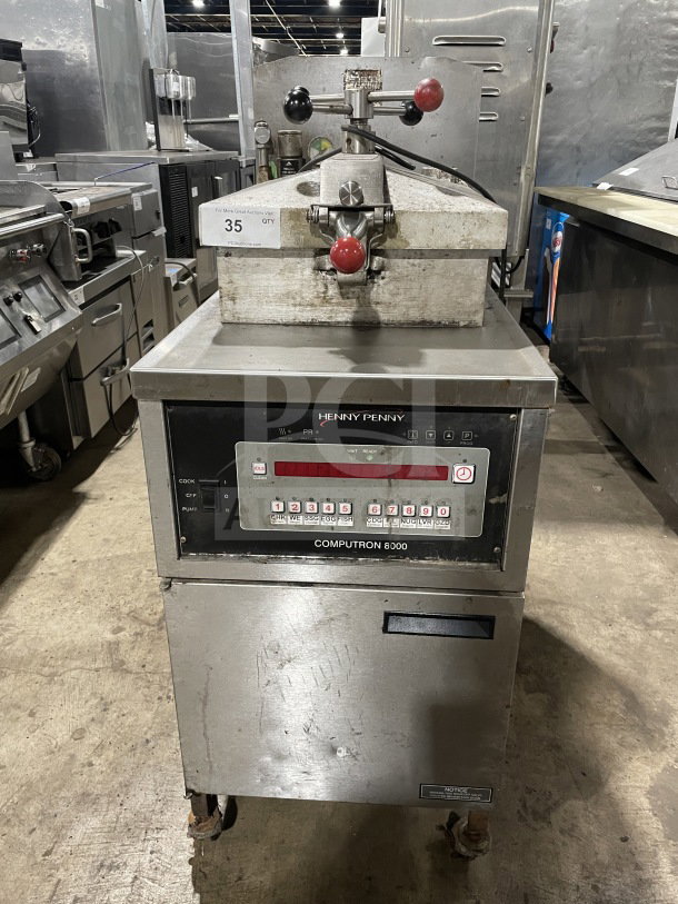 Henny Penny Model 600RB stainless steel gas-powered pressure fryer, on casters. Features visible markings and control panel.