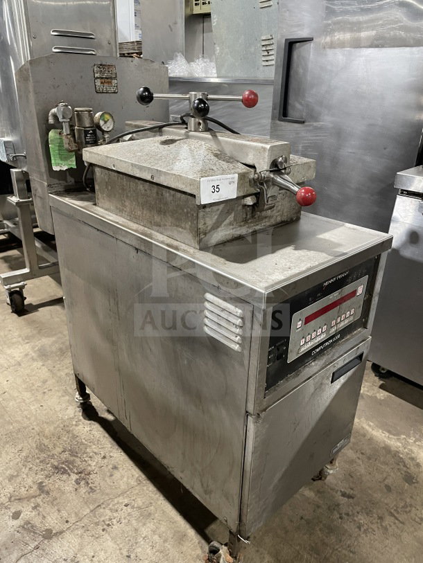 Henny Penny 600RB gas-powered pressure fryer, stainless steel, on casters. Used condition, model and serial numbers visible.