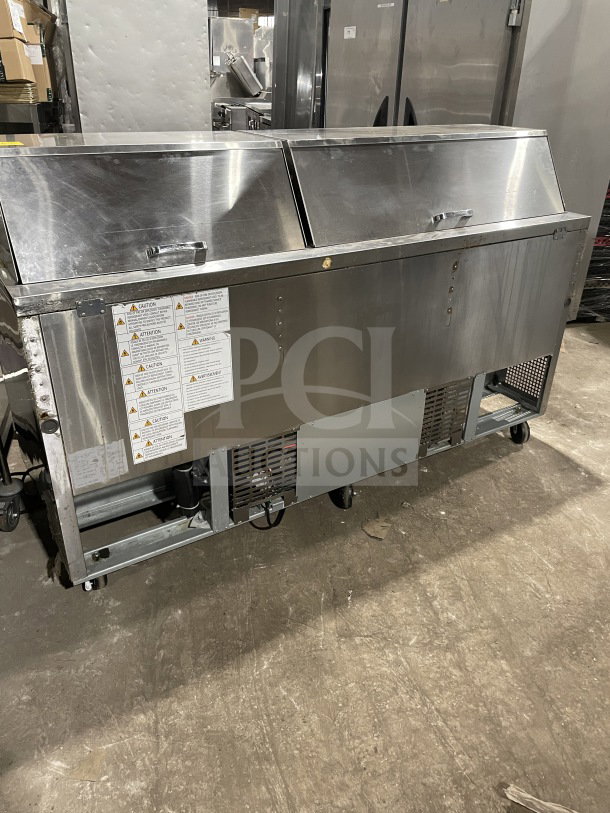 Turbo Air TST-72SD-30-N stainless steel 3-door refrigerated bain marie prep table with cutting board, on casters.