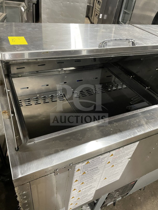 Turbo Air TST-72SD-30-N 3-door stainless steel prep table, bain marie style, features chrome rack, and cutting board.