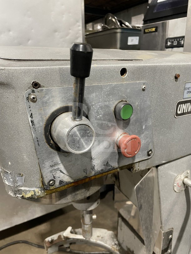 Uniworld commercial stainless steel planetary mixer with control levers and buttons, showing signs of use.