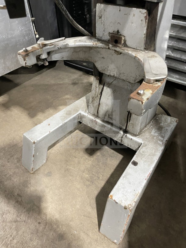 Uniworld commercial stainless steel planetary mixer base, showing signs of wear, ideal for heavy-duty mixing tasks.