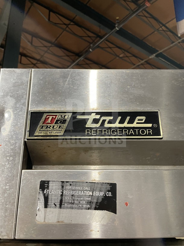 True T-49 stainless steel 2-door refrigerator, Energy Star certified, on casters, model and service stickers visible.