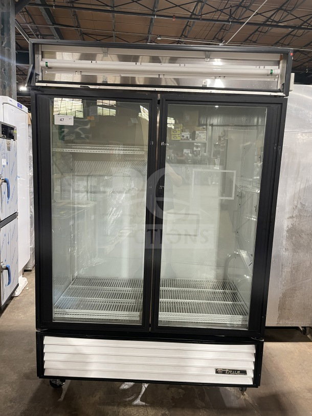 True GDM-49 commercial glass double swing door refrigerator with poly-coated wire rack; 115V, 1 phase, on casters.