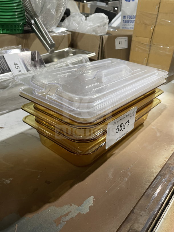 Stack of new amber food storage containers with clear lids. Labels show "55X3 QT." Pristine condition, unused.