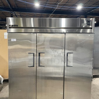 True 78" Commercial 3-Door Freezer, Model TR3F3S, stainless steel, on casters, with chrome-plated wire rack.