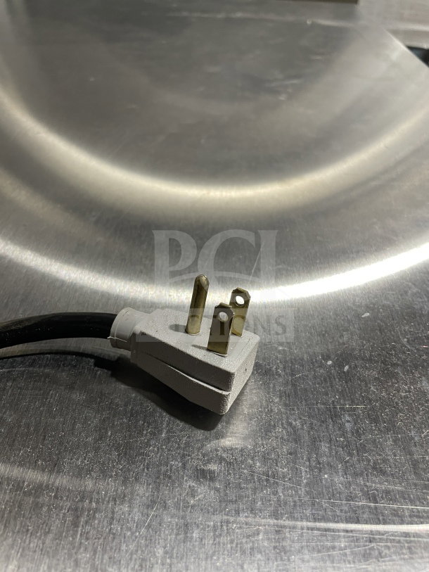 Close-up view of a three-prong plug on a stainless steel surface, part of a True Commercial Undercounter Refrigerator, model TUC-48-LP-HC~SPEC3.