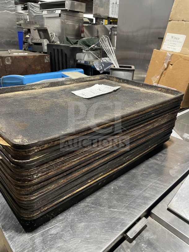 Stack of commercial aluminum full-size baking sheet pans, used condition, visible wear. Auction bid for 5 times value.