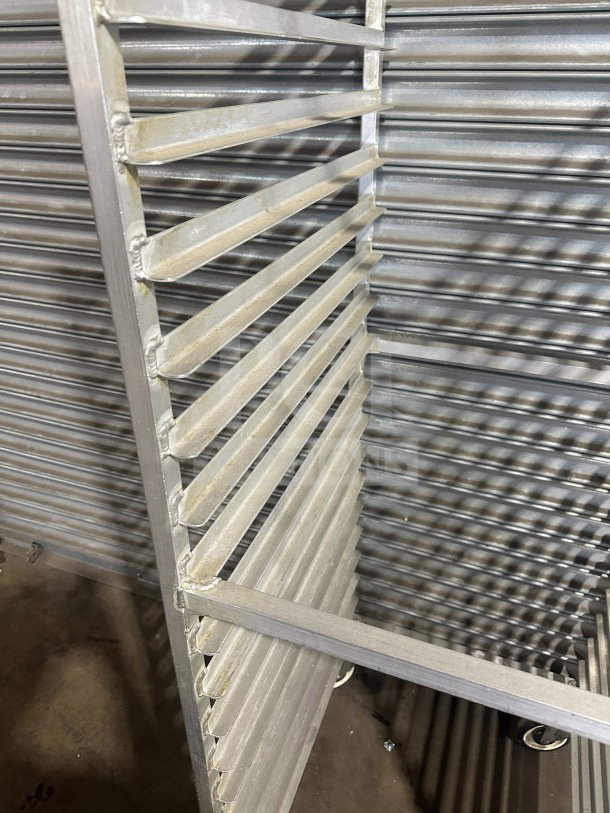 Commercial stainless steel sheet pan rack, heavy-duty, on casters. Multiple shelves, durable condition, ideal for kitchens.