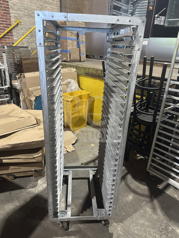 Commercial stainless steel sheet pan rack on casters, heavy-duty with multiple slots, good condition.
