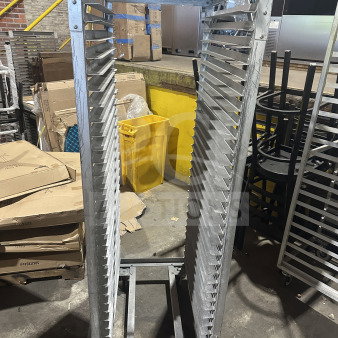 Commercial stainless steel sheet pan rack on casters, heavy-duty with multiple slots, good condition.