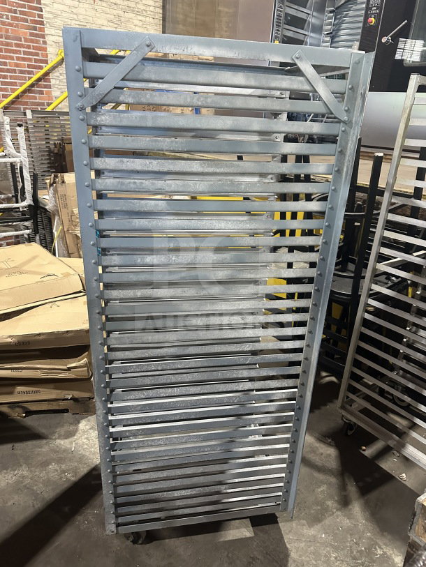 Commercial stainless steel heavy-duty sheet pan rack on casters, good condition, multiple slots, industrial use.