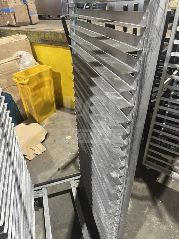 Commercial stainless steel heavy-duty sheet pan rack on casters, multiple shelves, industrial use, sturdy condition.