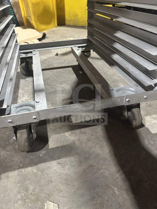 Commercial stainless steel sheet pan rack on casters; heavy-duty design, sturdy construction, ideal for bakery use.
