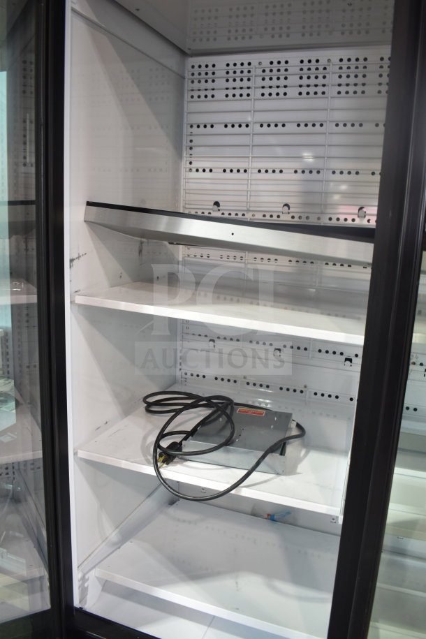 True TRM3M-YY-BLK-WHT-1BLKLLL-4 commercial three-door glass merchandiser with LED lighting, shelves, and cables shown.