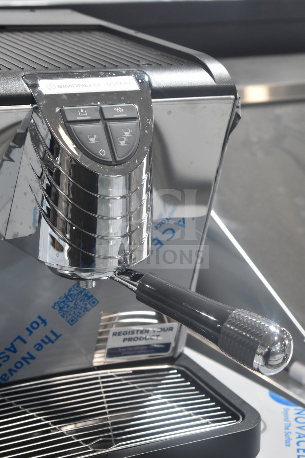 Brand new Nuova Simonelli OSCAR II AD espresso machine, single group, 110-120V, polished chrome finish, slight dents visible.