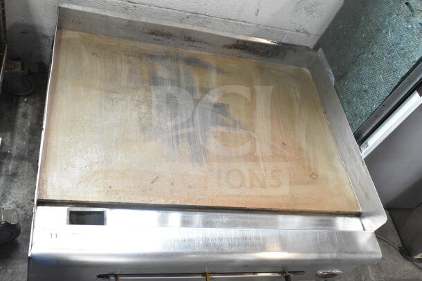 Wells Commercial Countertop Gas Griddle with flat top, stainless steel, signs of use, visible temperature control knob.