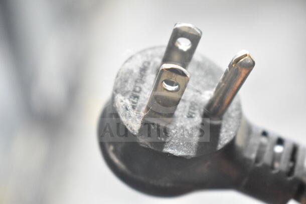 Close-up of a power plug for a 2018 True GDM-49-HC cooler, 115 volts, showing prongs and slight wear.