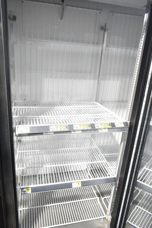 2018 True GDM-72F-HC commercial reach-in freezer with three glass doors, shelving, and visible pricing labels.