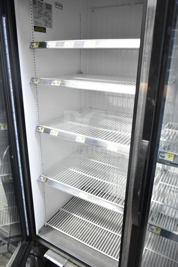 2018 True GDM-72F-HC commercial 3 door reach-in freezer, tested and working, shown with open shelves and interior tags.