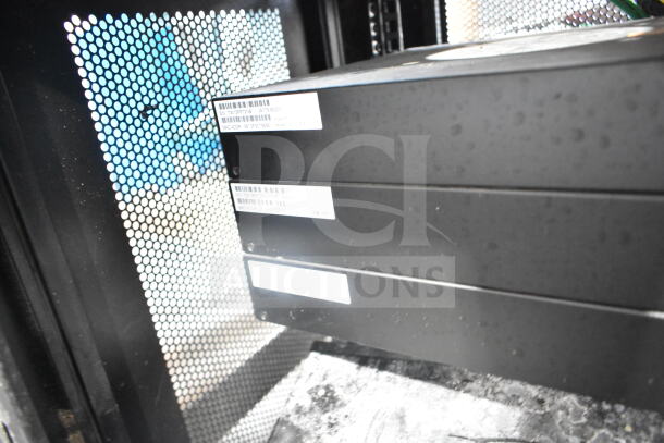 Tripp Lite AV cabinet with contents, features perforated door, equipment with visible labels, sturdy black metal.