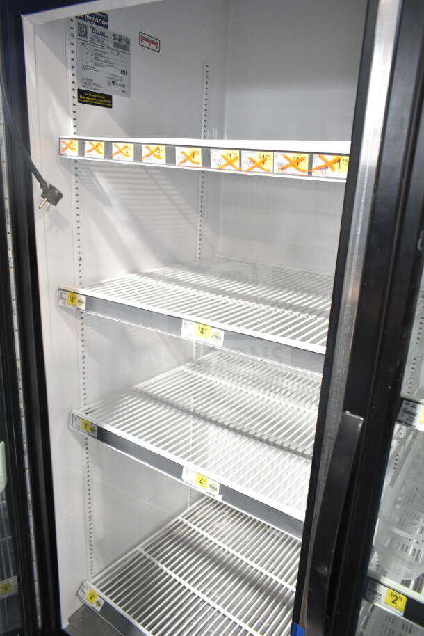 2018 True GDM-72-HC commercial cooler, 3 glass doors, 115 volts, tested working, white shelves, item labels visible.