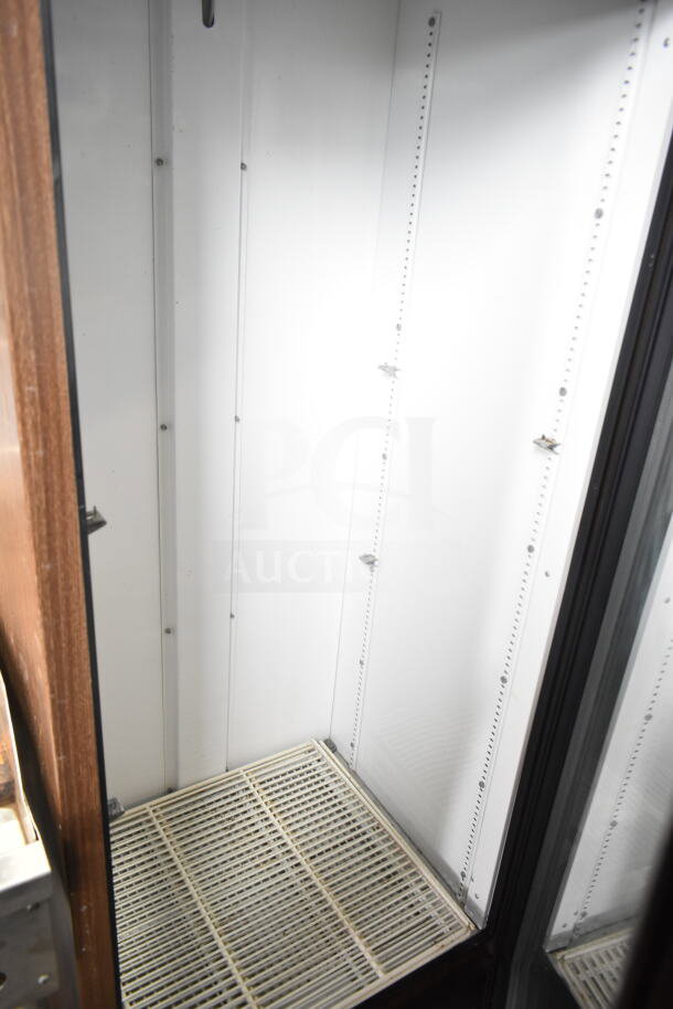 True GDM-19 commercial single door cooler merchandiser, interior view, 115 volts, 1 phase, good condition, white shelves.