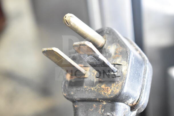 Turbochef NGC oven plug detail showing a 3-prong connector with signs of wear, indicating a 208/240V, 1-phase connection.
