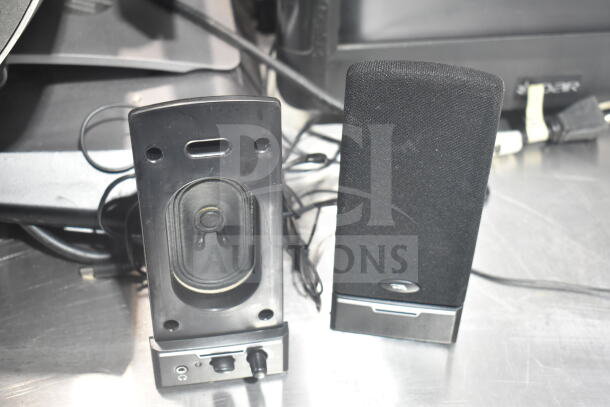 POS system with two black speakers, front and rear view shown. The speakers have volume control and appear in good condition.