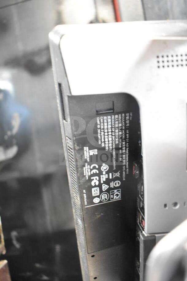 Rear view of POS system showing ports and power input. Includes regulatory labels, CE and FCC markings, model details.