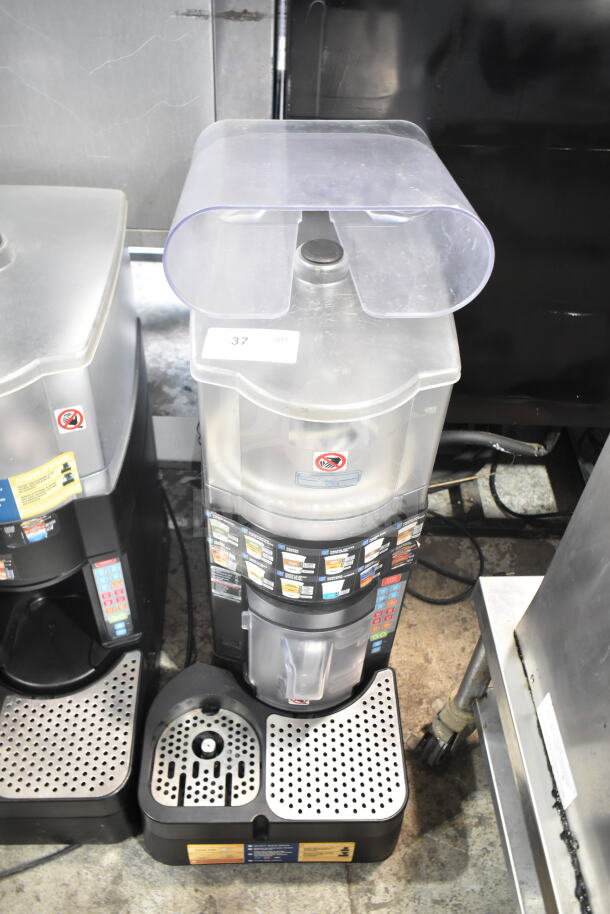 Taylor X83684-12 frozen beverage drink mixing machine, commercial countertop model. Features clear container and control panel.
