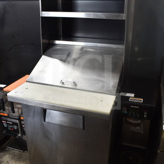 True TSSU-27-12M-B Commercial Sandwich Prep Table with 2-tier overshelf, stainless steel finish, on commercial casters.